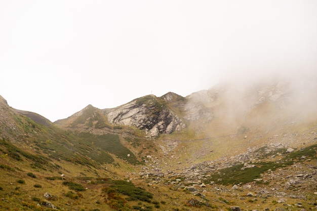 Catena montuosa con sagome visibili attraverso la nebbia colorata mattutina