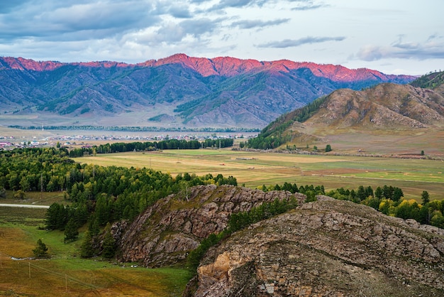 Catena montuosa illuminata dalla luce del tramonto Russia montagna Altai Ursul fiume Karakol e villaggi Kurota