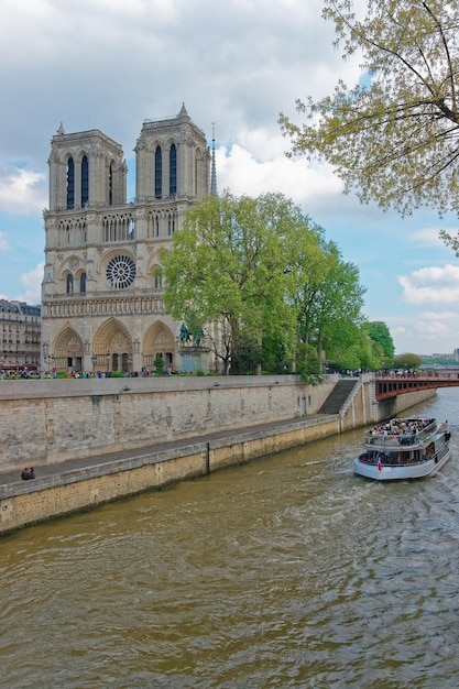 Cattedrale di Notre Dame de Paris, battello fluviale e argine della Senna a Parigi, Francia. O la Cattedrale di Nostra Signora di Parigi in inglese. Persone sullo sfondo