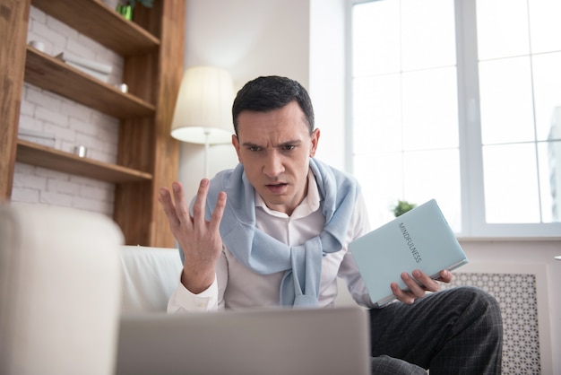 Cattive notizie. Libro della holding dell'uomo arrabbiato insoddisfatto durante l'utilizzo del computer portatile