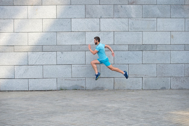 Catturato in movimento vista laterale dell'uomo jogger, concetto di forma perfetta.