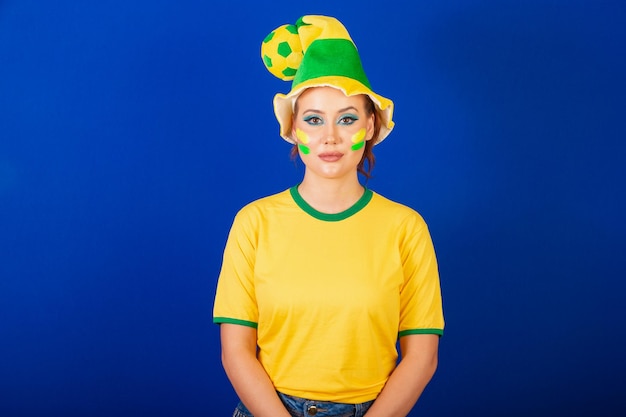 Caucasica donna rossa Brasile tifoso di calcio Sfondo blu brasiliano che indossa il cappello