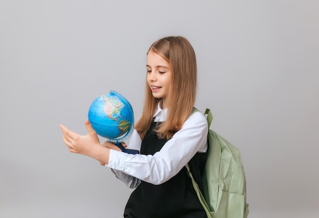 Caucasica giovane studentessa adolescente in possesso di un globo su uno sfondo grigio isolato Felice giornata della terra