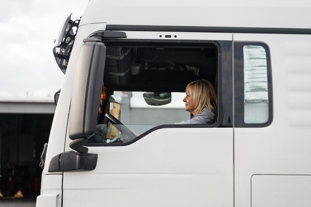 Caucasica metà età donna alla guida di camion camionista lavoratrice industria dei trasporti occupazione