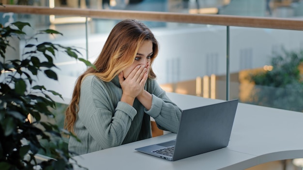 Caucasica stressante donna d'affari con laptop frelancer ragazza frustrata lettura scioccata male online