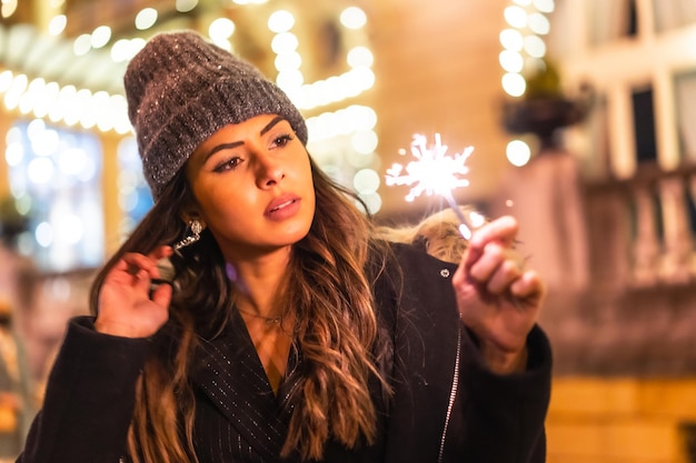 Caucasico in città di notte accanto alle luci di Natale