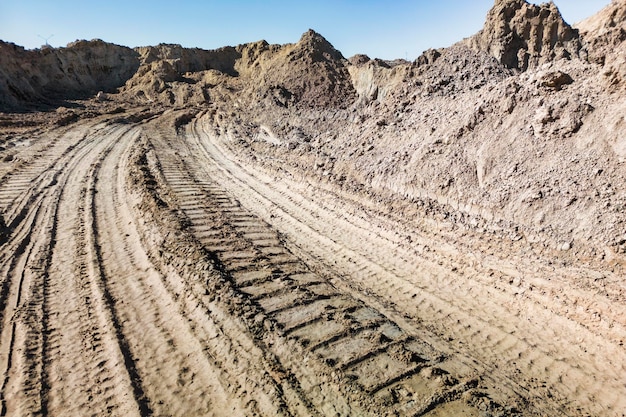 Cava di sabbia aperta per l'estrazione della sabbia durante la costruzione La consistenza della sabbia e le tracce del battistrada delle auto di grandi dimensioni Sabbia per lavori di costruzione Stoccaggio della sabbia in cantiere