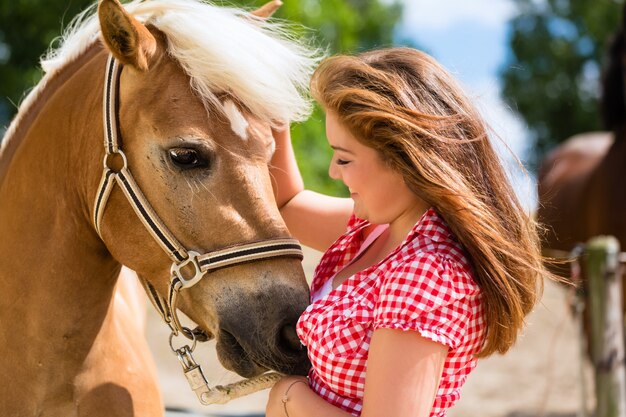 Cavallo di petting della donna sull&#39;azienda agricola del cavallino