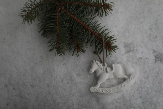 Cavallo giocattolo di Natale appeso su un ramo verde nella neve in inverno Regalo di cavallo giocattolo albero di Natale Decorazioni di Capodanno