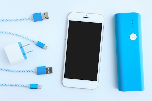 Cavi di ricarica USB con smartphone e batteria in vista dall'alto