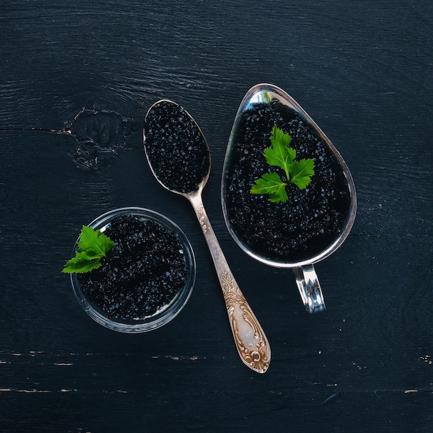 Caviale nero Caviale di storione Su fondo di legno Vista dall'alto Spazio libero per il testo