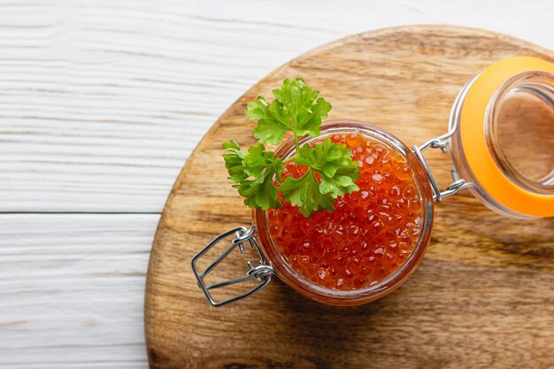 Caviale rosso con prezzemolo in un barattolo