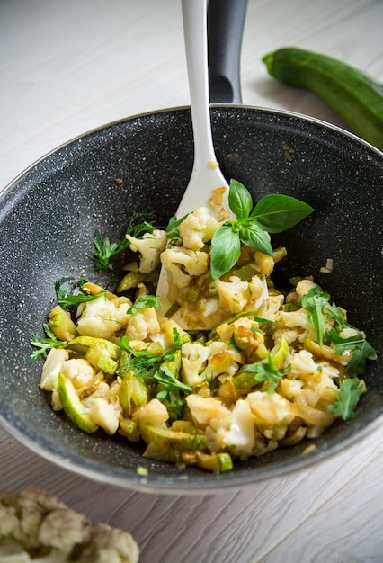 Cavolfiore fritto con zucchine e verdure in padella con erbe aromatiche