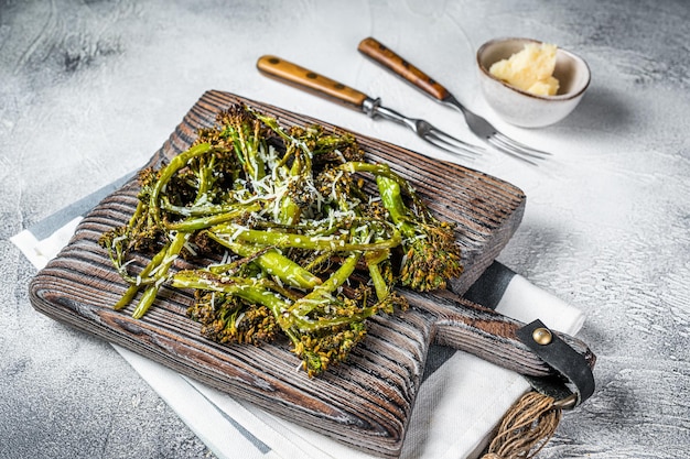 Cavolo Broccolini al forno Germogli con parmigiano su tavola di legno Sfondo bianco Vista dall'alto