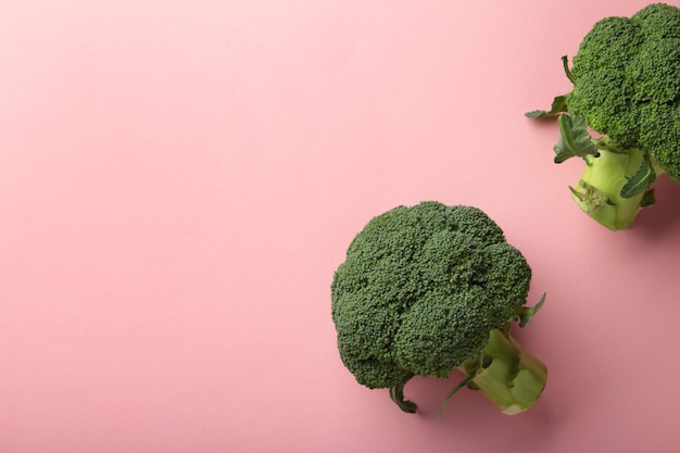 Cavolo broccolo su sfondo rosa. Modello di cavolo broccolo fresco. Vista dall'alto.