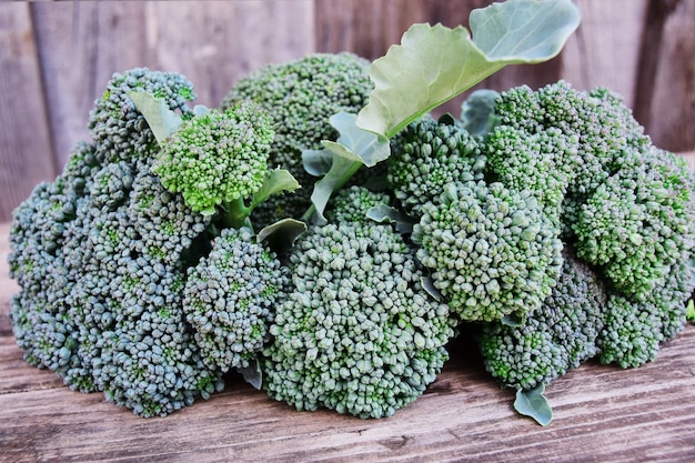 Cavolo fresco dei broccoli del raccolto su fondo di legno, primo piano. concetto di coltivazione di cavoli broccoli.