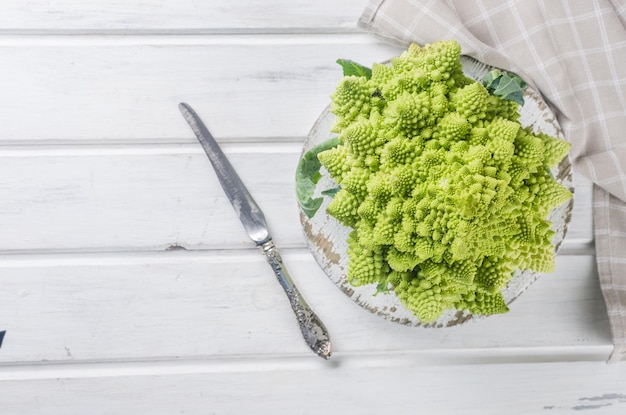 Cavolo fresco romanesco su fondo di legno bianco