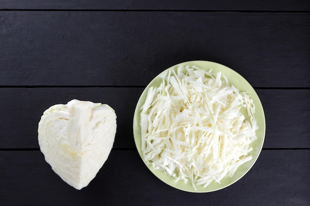 Cavolo tritato su sfondo scuro Cavolo bianco sul piatto verde Verdure fresche su tavole nere Copia spazio