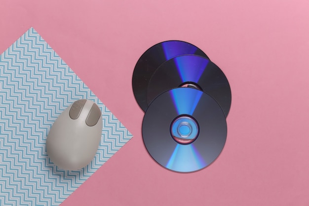 CD retrò vecchio stile e mouse per PC su pastello blu rosa