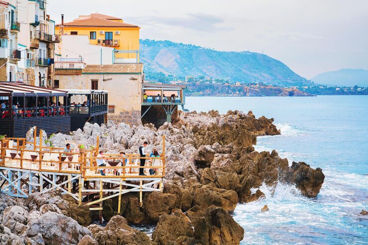 Cefalù, Italia - 26 settembre 2017: Persone al ristorante sulla costa rocciosa a Cefalù città vecchia, regione Palermo, Sicilia isola in Italia