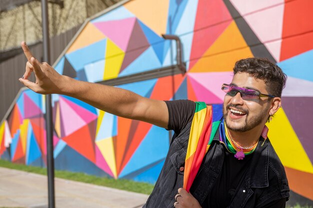 Celebrando la diversità Gay sorridente con bandiera dell'orgoglio nel parco