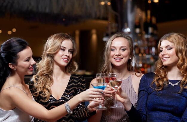 celebrazione, amici, addio al nubilato e concetto di vacanze - donne felici che bevono champagne e cocktail al night club