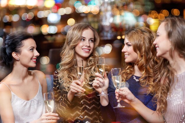 celebrazione, amici, addio al nubilato e concetto di vacanze - donne felici con bicchieri di champagne al night club