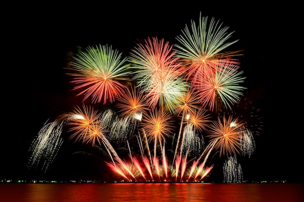 Celebrazione dei fuochi d'artificio dalla riva del mare. Celebrazione di fuochi d'artificio colorati e sullo sfondo del cielo notturno.