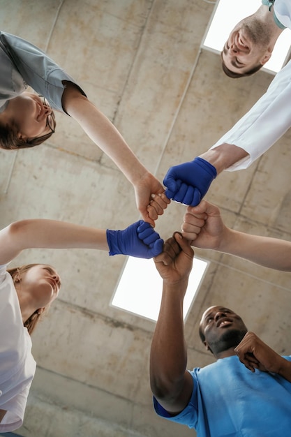 Celebrazione del successo, gesti con le mani, vista dal basso di un gruppo di medici.