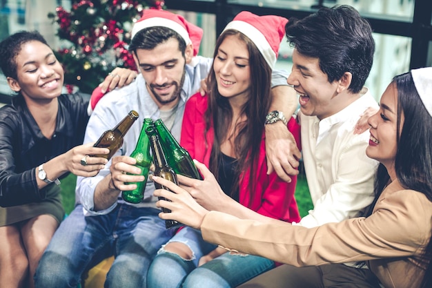 Celebrazione della festa Natale e Capodanno di impiegati di gruppo con bevande e birra ubriaca con divertimento e sorriso in ufficio. Concetto di festa di celebrazione.