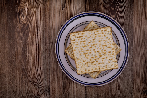 Celebrazione della Pasqua ebraica con pane azzimo matzah kosher sul tradizionale piatto di pesach della Pesach ebraica