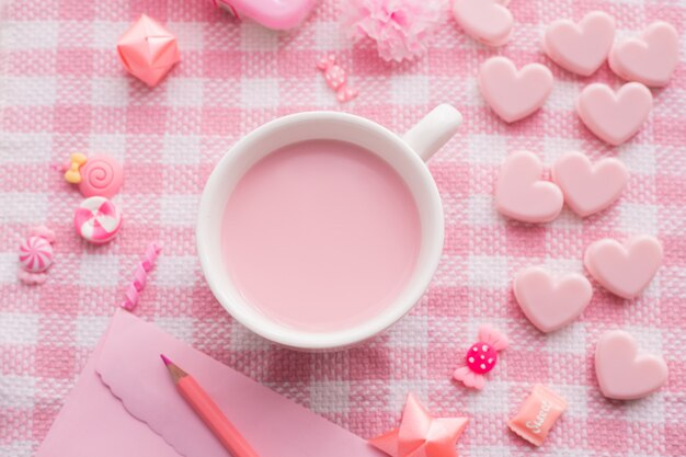 Celebrazione di festa di San Valentino con tazza di latte sulla tovaglia rosa