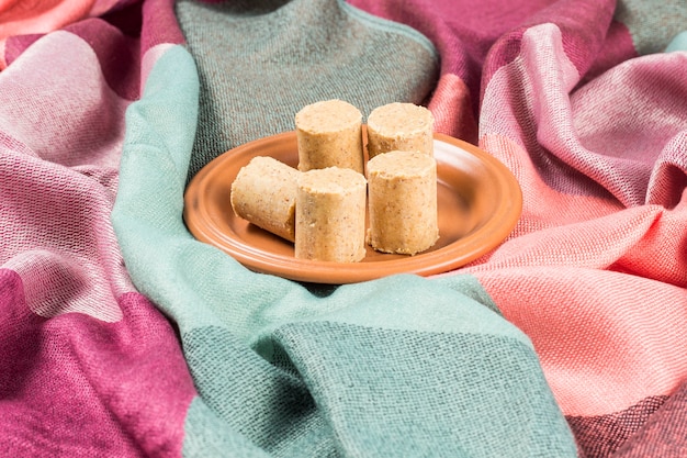 Celebrazione di giugno. L'arachide brasiliana dolce ha chiamato PaÃ§oca su un piatto su un tessuto colorato.