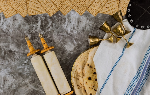 Celebrazione tradizionale del giorno di Pasqua con quattro coppe per vino e pane azzimo matzah kosher sul rotolo della torah della festa ebraica di Pesach