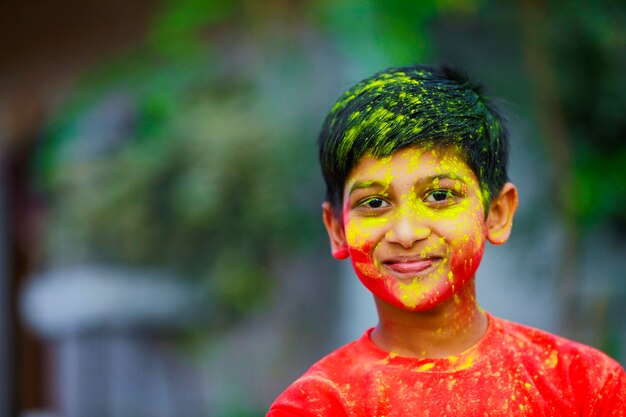 Celebrazioni Holi - Ragazzino indiano che gioca Holi e mostra l'espressione del viso.