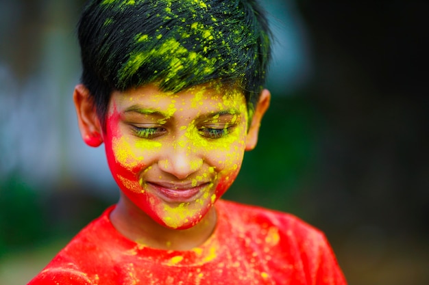 Celebrazioni Holi - Ragazzino indiano che gioca Holi e mostra l'espressione del viso.