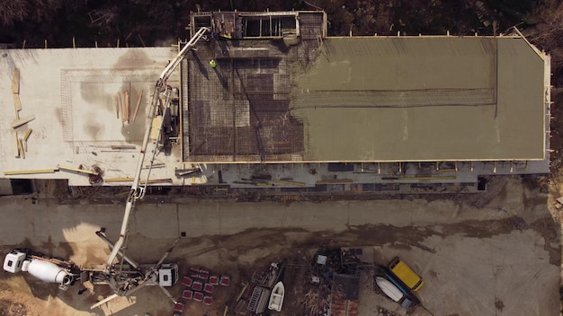 Cemento concreto sul tetto di un edificio in costruzione utilizzando una macchina per autocarro con pompa per calcestruzzo