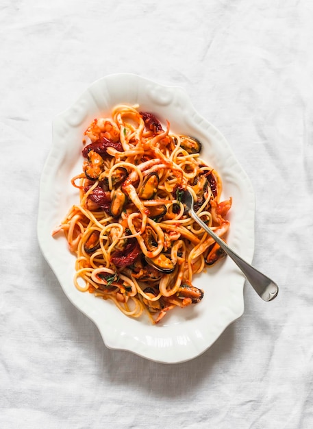 Cena deliziosa con salsa di pomodoro e frutti di mare su uno sfondo chiaro vista dall'alto