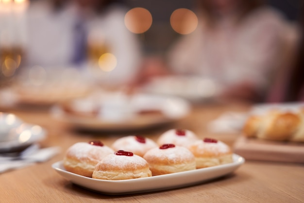 Cena di Hanukkah. Famiglia riunita intorno alla tavola con i piatti della tradizione