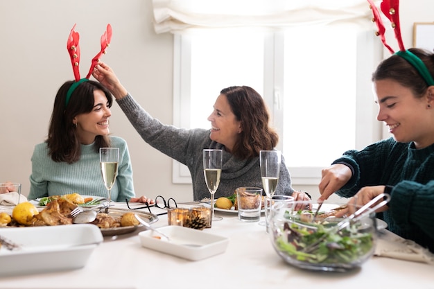Cena di Natale Madre condivide il pasto festivo con le figlie che indossano corna di renna in feltro Holiday