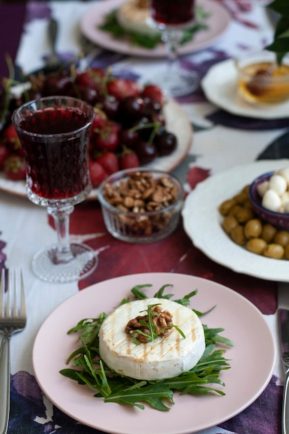 cena gourmet. Camembert alla griglia, vino bianco e vari antipasti.