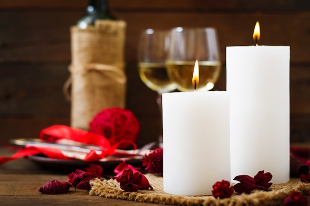 Cena romantica con candele, vino e petali