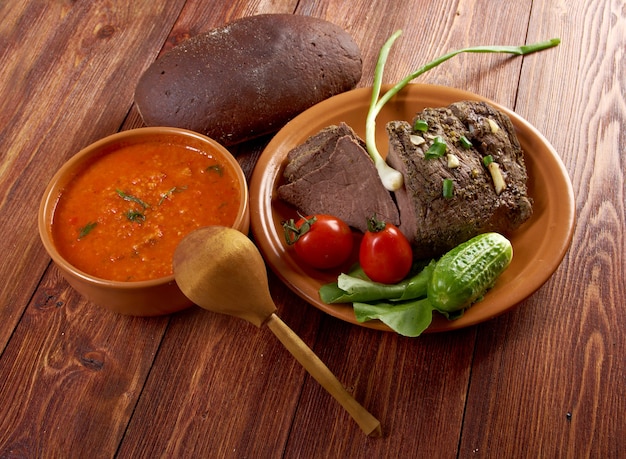 Cena rustica italiana - zuppa di pomodoro o Pappa al Pomodoro e arrosto di manzo e verdure con pane, in stile contadino