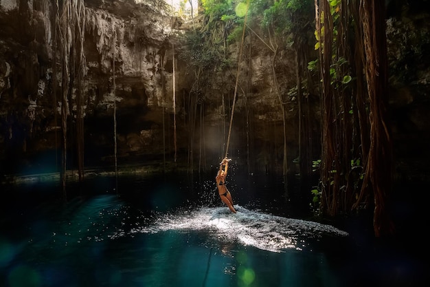 Cenote IkKil Yucatan Ragazza su un bungee Messico