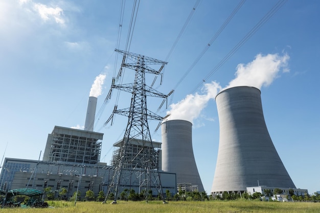 Centrale termica e pilone di trasmissione ad alta tensione contro un cielo blu