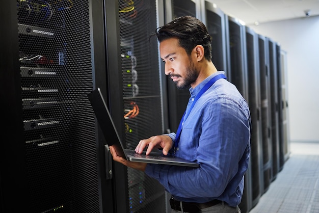 Centro dati di programmazione e un uomo con un laptop per la manutenzione della sicurezza informatica e il controllo di Internet Codifica della posta elettronica e un programmatore asiatico che digita su un computer per l'analisi della rete o del server