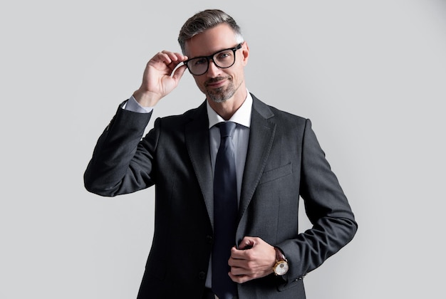 CEO maturo felice indossa un abito da lavoro su sfondo grigio