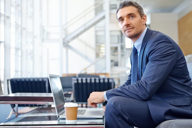 CEO o uomo d'affari che pensa in aeroporto con il computer portatile per la strategia di investimento finanza del mercato azionario o revisione finanziaria Professionista aziendale in attesa sul divano con tecnologia che fa ricerche sull'economia