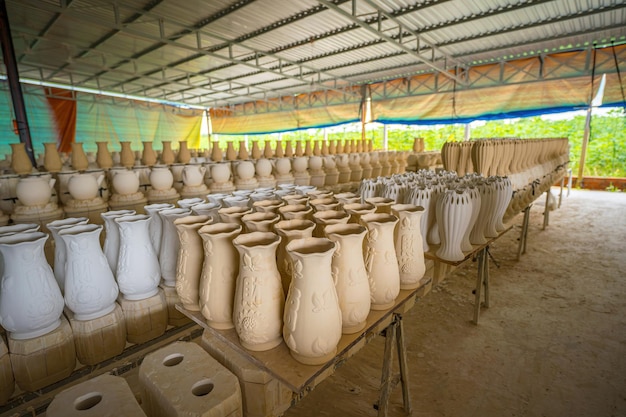 Ceramica posizionata in file in attesa di bruciare nella fabbrica di ceramica Stack di piccole tazze di ceramika grezze sullo scaffale stampo di tazze in ceramica processo tradizionale di produzione di tazzze in keramica in fabbrica