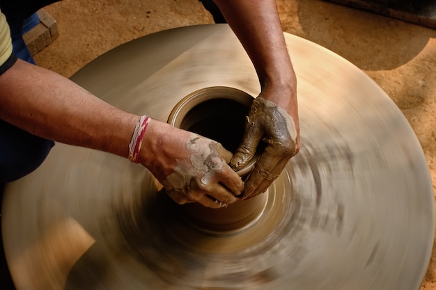 Ceramiche - abili mani bagnate del vasaio che modellano l'argilla sul tornio da vasaio